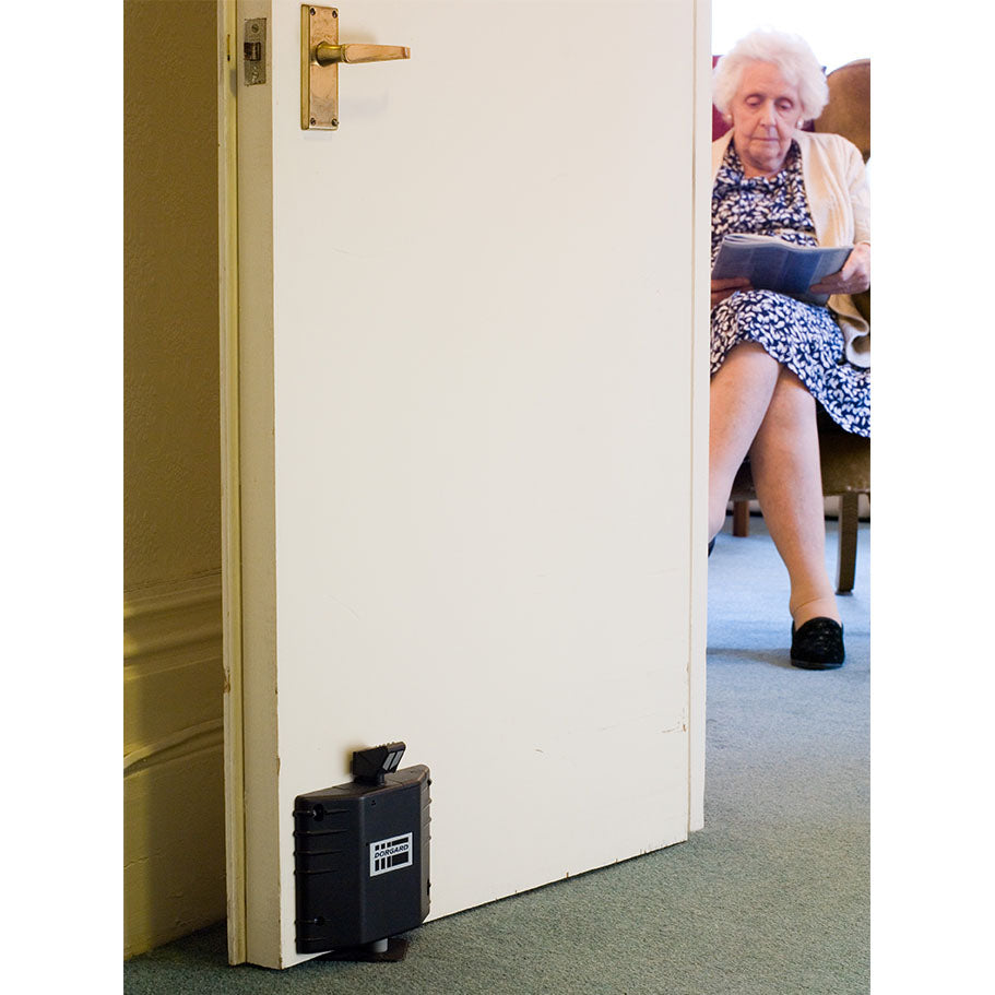 Fireco Dorgard SmartSound fire door retainer installed in a care-home corridor